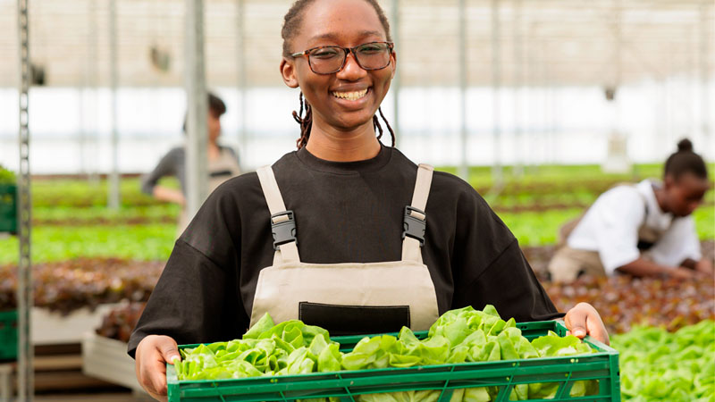 Woman holding a container of greens